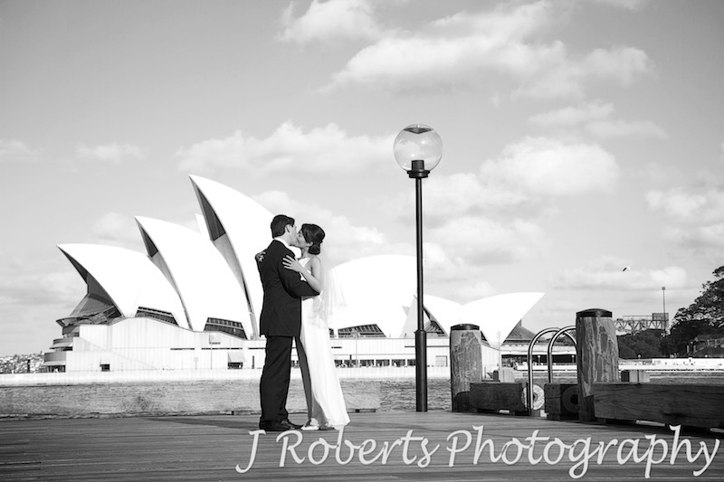 Wedding couple kissing at The Rocks Sydney with Opera House behind - wedding photography sydney